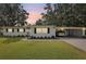 Charming single-story home featuring a carport, well-maintained lawn, and mature trees under a beautiful evening sky at 403 Westbrook Ave, Brandon, FL 33511