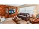 Comfortable living room featuring a brick wall, classic furniture, and ample lighting, creating a cozy and inviting space at 403 Westbrook Ave, Brandon, FL 33511