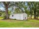 A white shed in the backyard underneath the canopy of a large oak tree at 403 Westbrook Ave, Brandon, FL 33511