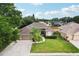 Aerial view of a well-maintained home with a large driveway, manicured lawn, and mature trees in a peaceful neighborhood at 4511 Swift Cir, Valrico, FL 33596