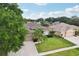 Aerial perspective of a beautifully landscaped home featuring a spacious driveway, well-kept lawn, and lush trees in a serene setting at 4511 Swift Cir, Valrico, FL 33596