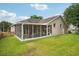 Expansive backyard view highlighting a screened-in patio, lush lawn, and the home's exterior, perfect for outdoor living and entertaining at 4511 Swift Cir, Valrico, FL 33596