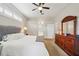 Well-lit bedroom featuring carpet, neutral walls, a ceiling fan, and view to en suite bathroom at 4511 Swift Cir, Valrico, FL 33596