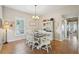Cozy dining room with a white table set, a chandelier, and natural light from the window at 4511 Swift Cir, Valrico, FL 33596