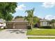 Charming single-Gathering home with a well-manicured lawn, mature landscaping, and an attached three-car garage at 4511 Swift Cir, Valrico, FL 33596