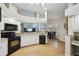 An eat-in kitchen with black appliances, white cabinets, granite countertops, and an open concept design at 4511 Swift Cir, Valrico, FL 33596