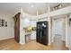 This kitchen features white cabinets, granite countertops, a black refrigerator and unique barn door design at 4511 Swift Cir, Valrico, FL 33596