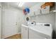 Bright laundry room featuring a modern washer and dryer, storage shelving, and clean white walls at 4511 Swift Cir, Valrico, FL 33596