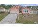 Inviting single-story home with a manicured lawn, attached garage, and decorative white picket fencing at 4617 Horseshoe Pick Ln, Valrico, FL 33594