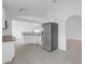Bright kitchen with white cabinets, stainless steel refrigerator, granite counters, and tiled floor at 4617 Horseshoe Pick Ln, Valrico, FL 33594