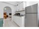 Modern kitchenette with white cabinets, stainless steel appliances, and tiled flooring at 4617 Horseshoe Pick Ln, Valrico, FL 33594
