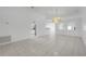 Spacious living room with bright, neutral walls, tile floors, and an elegant chandelier at 4617 Horseshoe Pick Ln, Valrico, FL 33594
