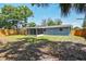 The backyard showcases a full privacy fence and an attached screened-in porch at 4940 Rosedale Ln, Holiday, FL 34690