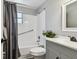 Bathroom featuring a tub-shower combo, toilet, gray vanity, and a large decorative mirror at 4940 Rosedale Ln, Holiday, FL 34690