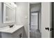 Bathroom vanity featuring a decorative mirror, overhead lighting, and tile flooring at 4940 Rosedale Ln, Holiday, FL 34690