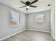 Bedroom featuring new floors, ceiling fan, and two windows at 4940 Rosedale Ln, Holiday, FL 34690