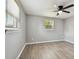 Bedroom featuring new floors, ceiling fan, and view of outside at 4940 Rosedale Ln, Holiday, FL 34690