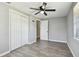 Bedroom featuring new floors, ceiling fan, and double door closet at 4940 Rosedale Ln, Holiday, FL 34690