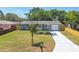Charming single-story home featuring a freshly painted driveway, manicured lawn, and a cozy one car garage at 4940 Rosedale Ln, Holiday, FL 34690