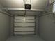 View of the garage door with a door opener, within a clean and functional garage space, providing secure parking at 4940 Rosedale Ln, Holiday, FL 34690
