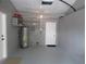 Spacious garage featuring a water heater and access door, offering ample space for parking and storage solutions at 4940 Rosedale Ln, Holiday, FL 34690