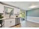 Bright kitchen featuring white cabinetry, stainless steel appliances, quartz countertops, and sliding glass doors to the backyard at 4940 Rosedale Ln, Holiday, FL 34690