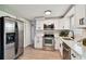 Modern kitchen with stainless steel appliances, white cabinets, and stone countertops at 4940 Rosedale Ln, Holiday, FL 34690