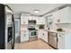 Modern kitchen with stainless steel appliances, white cabinets, and stone countertops at 4940 Rosedale Ln, Holiday, FL 34690
