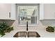 Stainless steel double sink, dark faucet, and white quartz countertops beneath a window offer both style and functionality at 4940 Rosedale Ln, Holiday, FL 34690