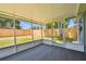 Cozy screened porch with carpeted floor, offering views of the fenced backyard and green space at 4940 Rosedale Ln, Holiday, FL 34690