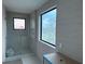 Bright bathroom featuring a glass-enclosed shower, gray tiled walls, and a large window at 501 W Ross Ave # 2, Tampa, FL 33602