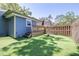 Artificial turf backyard featuring wooden steps to a porch, a shed, and a tall wooden fence at 5304 Cherry Ave, Seffner, FL 33584