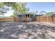 The gravel backyard leads up to a house with a fenced in porch area and a wooden fence at 5304 Cherry Ave, Seffner, FL 33584