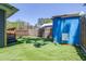 Backyard featuring wooden fences, artificial turf, and a blue shed for storage and lawn maintenance at 5304 Cherry Ave, Seffner, FL 33584