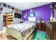 Comfortable bedroom showcasing purple accent wall, TV, and walk-in closet at 5304 Cherry Ave, Seffner, FL 33584