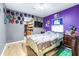 Comfortable bedroom showcasing purple accent wall, TV, and walk-in closet at 5304 Cherry Ave, Seffner, FL 33584