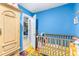 Bright bedroom featuring blue walls, and a wooden crib, creating a cozy and inviting space for a  at 5304 Cherry Ave, Seffner, FL 33584