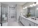 Modern bathroom with double vanity, large mirror, and glass enclosed shower with white tile at 5727 Silverside Pine Ct, Lakewood Ranch, FL 34211