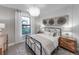 Bright bedroom with decorative chandelier, large window, and comfortable linens at 5727 Silverside Pine Ct, Lakewood Ranch, FL 34211