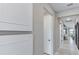 Hallway with tiled floors, white doors and decorative accents at 5727 Silverside Pine Ct, Lakewood Ranch, FL 34211