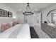 This primary bedroom features a large bed, decorative pillows and circular chandelier at 5727 Silverside Pine Ct, Lakewood Ranch, FL 34211