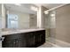Bathroom featuring double sink vanity with granite countertop and a walk-in shower with glass enclosure at 6306 Tillandsia Pl, Tampa, FL 33610