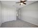 Bedroom with neutral walls, gray carpet, ceiling fan and a closet with doors open at 6306 Tillandsia Pl, Tampa, FL 33610