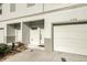 Townhouse entrance featuring a garage and door under a gray-trimmed roof at 6306 Tillandsia Pl, Tampa, FL 33610