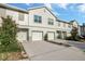 A townhouse complex featuring a garage and a quaint walkway to the front door at 6306 Tillandsia Pl, Tampa, FL 33610