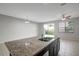 Kitchen island with granite countertops and stainless steel sink overlooks the spacious living area at 6306 Tillandsia Pl, Tampa, FL 33610