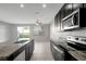 Open kitchen with stainless steel appliances, granite countertops, and adjacent living area at 6306 Tillandsia Pl, Tampa, FL 33610