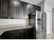 Modern kitchen with stainless steel refrigerator, granite countertops, and dark wood cabinets at 6306 Tillandsia Pl, Tampa, FL 33610