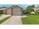 Charming exterior featuring brick accents, a well-maintained lawn, and a paved driveway at 6514 Thicket Trl, New Port Richey, FL 34653