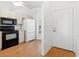 Cozy kitchen with white cabinets, black appliances, and wood laminate flooring at 6514 Thicket Trl, New Port Richey, FL 34653